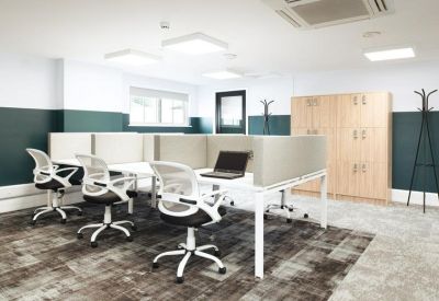 Bright coworking area with white ergonomic chairs and wood-look lockers.
