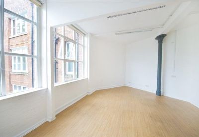 Empty office suite with white walls and dark structural pillars.