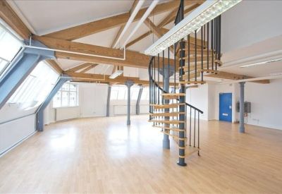 Spacious loft-style office featuring exposed timber beams and a spiral staircase.