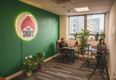 Bright private office featuring a green feature wall and large windows.