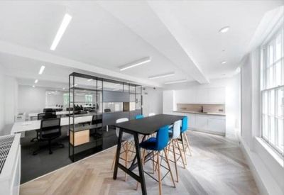 Breakout area with a high black communal table and blue bar stools.
