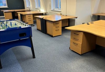 Open-plan workspace featuring arched windows and a blue foosball table.