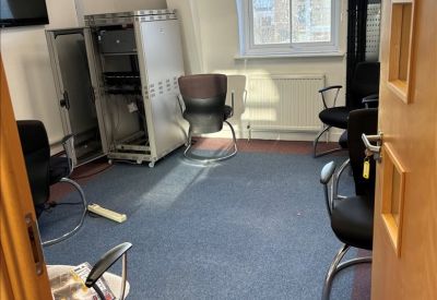 Meeting or server room with black office chairs and a large equipment rack.