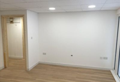 Bright, empty office suite with light wood flooring and neutral walls.