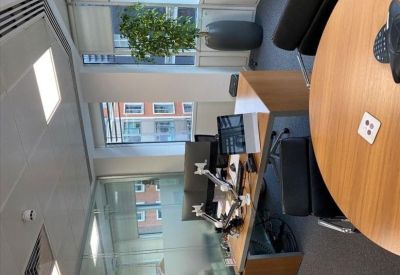 Private office space at 35 Park Lane with large windows overlooking city buildings and a potted plant.