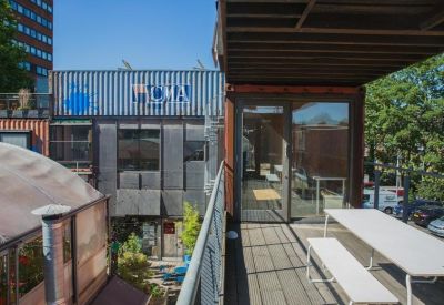 Elevated outdoor walkway overlooking a shipping container development.