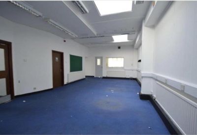 Bright internal office room with blue flooring and white walls.