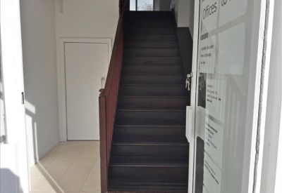 Entrance stairwell with dark wood stairs leading to the upper office floors.