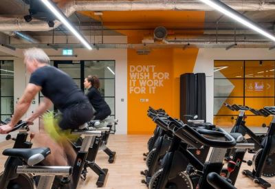 Indoor cycling studio with stationary bikes and orange motivational wall graphics.
