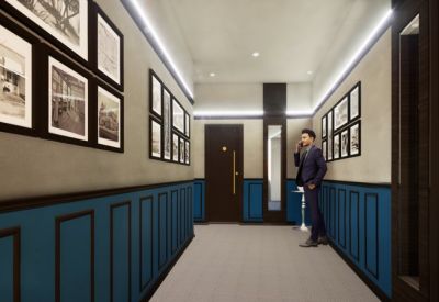Stylish corridor with blue wainscoting, framed historical photos, and warm lighting.