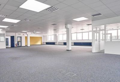 Large open-plan workspace with grey carpeting and white pillars.