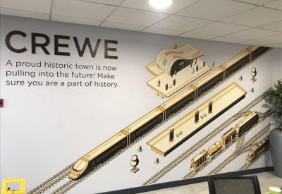 Modern reception area with a large illustrative wall mural featuring a train and station platform.