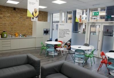 Breakout space with grey sofas and white circular tables paired with colorful chairs.