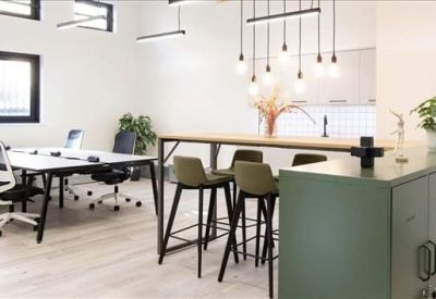 Lounge space featuring a long wooden breakfast bar, green storage lockers, and hanging light bulbs.