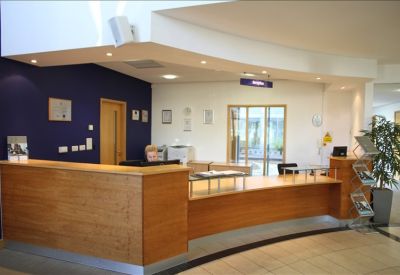 Bright reception area featuring a long wooden desk and a deep blue feature wall.