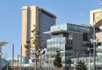 Distant view of modern city skyline and glass office buildings.