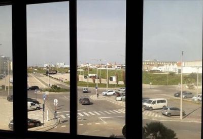 Wide window view from the office showing a busy street crossing and distant buildings.
