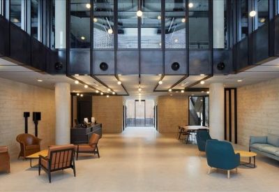 Modern reception lobby featuring contemporary armchairs and a mezzanine level with black steel accents.