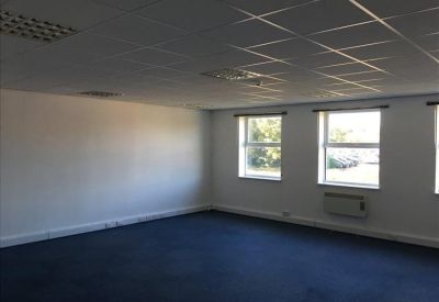 Empty professional suite featuring dark blue floors and multiple windows for natural light.