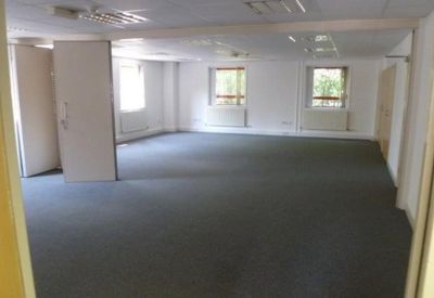 Large empty workspace featuring multiple windows and perimeter heating.