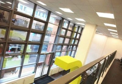 Double-height lobby area with glass frontage and a mezzanine walkway.