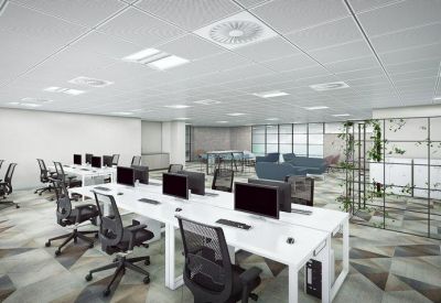 Open-plan office with white workstations, ergonomic black chairs, and geometric patterned flooring.