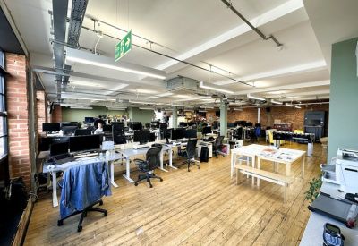 Wide-angle view of a large open-plan workspace with multiple rows of desks and computers.
