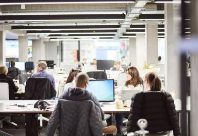Open-plan workspace filled with natural light and multiple rows of workstations.