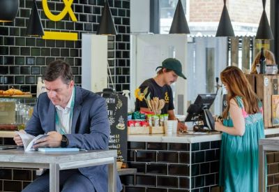Industrial-style café with black subway tiles and yellow accents.