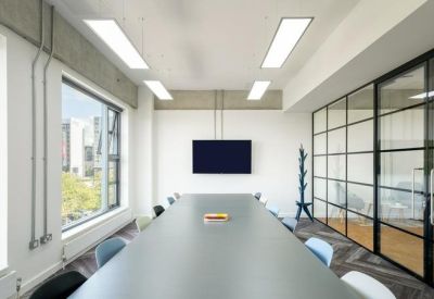 Modern meeting room with a long grey table and glass partition wall.