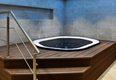 Indoor relaxation area featuring a built-in hot tub on a wooden deck.