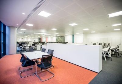 Breakout area featuring a square meeting table on vibrant orange carpeting.