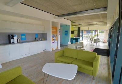 Communal area with green and blue sofas, and wall art.