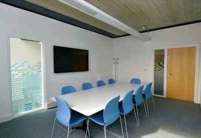 Meeting room with long table and blue chairs.