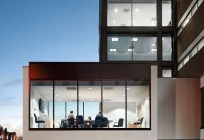 Meeting room with large windows showing people in a collaborative discussion.