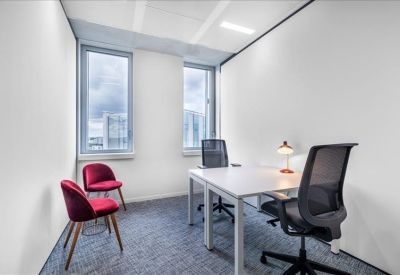 Bright private office suite with two desks and red accent chairs.