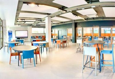 Spacious communal lounge and dining area with varied seating and natural light.