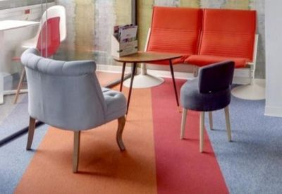 Lounge area with red sofas and colorful carpet.