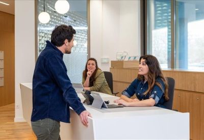 Bright reception desk with wooden wall panels and welcoming staff.