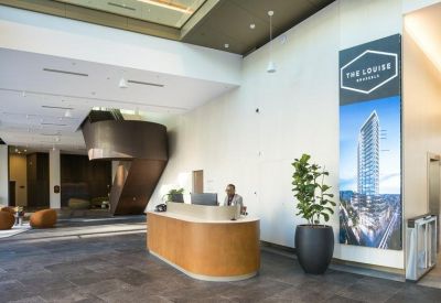 Spacious reception area at 149, Avenue Louise, Brussels featuring a wooden desk and large building banner.