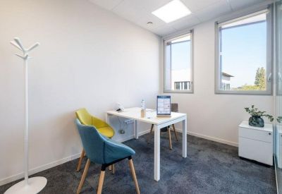 Bright two-person office suite with yellow and blue chairs and large windows.