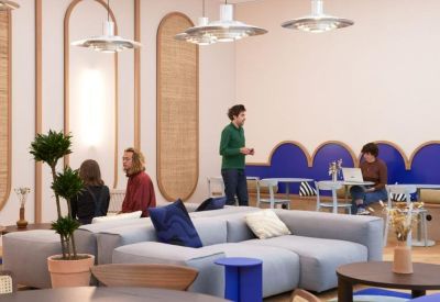 Spacious communal lounge with a grey sectional sofa, blue accents, and large arched wall features.