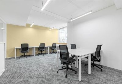 Large conference room featuring red mesh chairs and a long white table under bright windows.