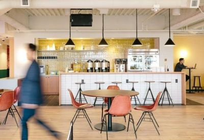 Cafe-style kitchen and dining area with a white tiled bar, wood flooring, and orange chairs.