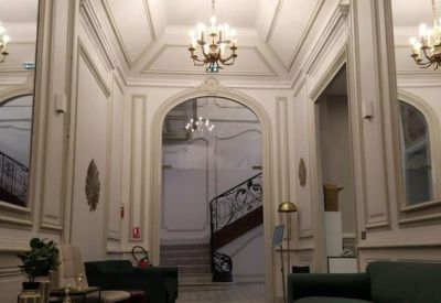 Spacious lobby with high arched doorways and multiple crystal chandeliers.