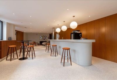 Communal break area with a curved white counter and wooden bar stools.