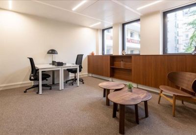 Spacious private office at 185 Avenue du Général de Gaulle with wooden cabinets and two desks.