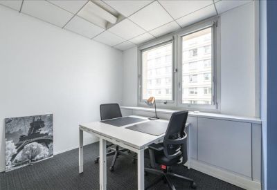 Private two-person office suite with white desks and natural light from large windows.