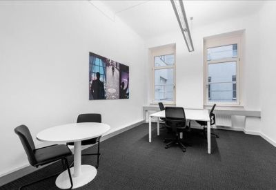 Small meeting room with a round white table and a contemporary black and white art piece.