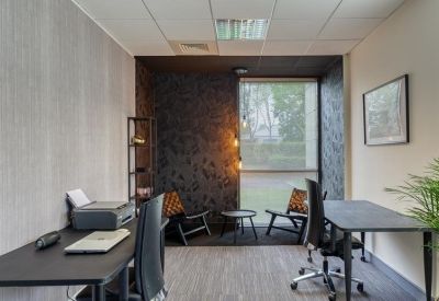 Private internal office suite with two desks, a printer, and a small sitting area.
